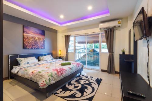 a bedroom with a bed with a purple ceiling at Kanokkan Apartment in Hua Hin