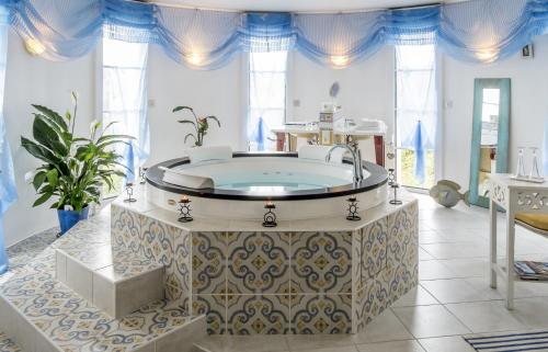 B&B Le Vert Galant في Normanville: حمام كبير مع حوض في الغرفة