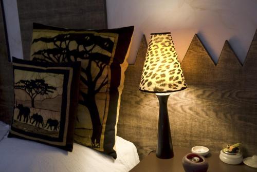 a lamp sitting on a table next to a bed at B&B Le Vert Galant in Normanville