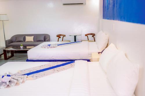 a room with two beds and a couch at Santiago Cove Hotel and Restaurant in Santiago
