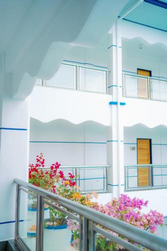 a balcony with flowers in front of a building at Santiago Cove Hotel and Restaurant in Santiago