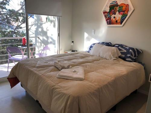 a large bed with two towels on it in a bedroom at Alumine in Puerto Madryn