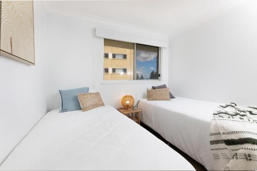 two beds in a room with a window at El Sandi, Unit 10, 14-18 North Street in Forster