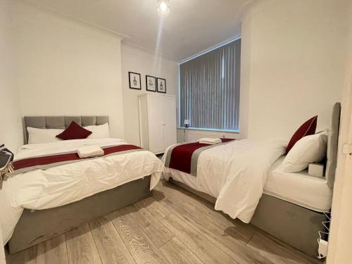 1 Schlafzimmer mit 2 Betten und einem Fenster in der Unterkunft Coast View Professional Let in Whitley Bay