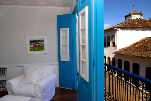 a room with a blue door and a white couch at Casa Turquesa - Maison D´Hôtes in Paraty
