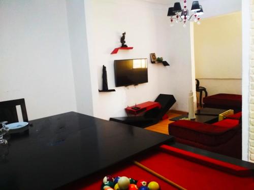 a living room with a table and a tv at Nice house in Alexandria