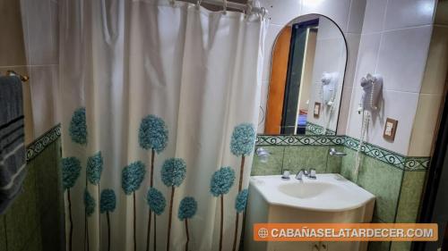 baño con lavabo y cortina de ducha con árboles en Cabañas el atardecer en San José
