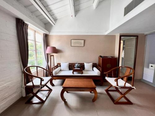 uma sala de estar com um sofá e duas cadeiras em Heritage Lodge em Hong Kong