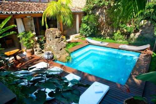 une image d'une piscine dans un jardin dans l'établissement Casa Turquesa - Maison D´Hôtes, à Parati