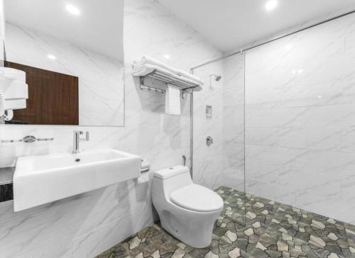 a white bathroom with a toilet and a sink at U3 HOTEL in Subang Jaya
