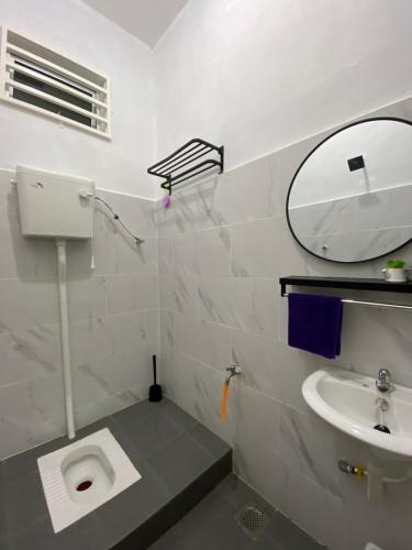 W łazience znajduje się umywalka, toaleta i lustro. w obiekcie De Jara Guesthouse Dungun for Malay w mieście Dungun