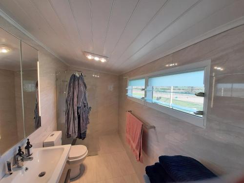 a bathroom with a sink and a toilet and a window at Alloway Bank in Bathurst