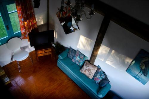 sala de estar con sofá azul y TV en Aquelarre en La Capuera