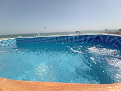 a large pool of blue water with a chair in it at Bungalow VerdeMar con Jacuzzi Frente al Mar in Vichayito