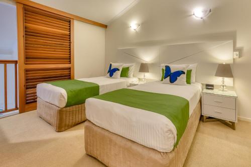 2 bedden in een hotelkamer met 2 eenpersoonsbedden bij Freestyle Resort Port Douglas in Port Douglas