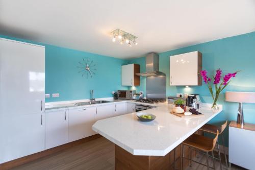 a kitchen with blue walls and a white counter top at Sowena in Carbis Bay