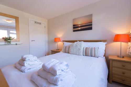 a bedroom with a white bed with towels on it at Sowena in Carbis Bay
