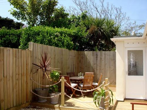 a patio with a table and chairs and a fence at Sowena in Carbis Bay