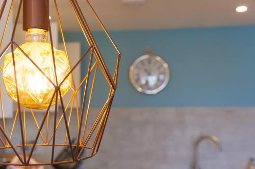 Una lámpara con un reloj al fondo en Sea Glass, en Carbis Bay