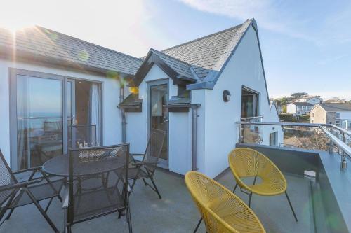 a patio with chairs and a table on a balcony at Sea Vista in Carbis Bay