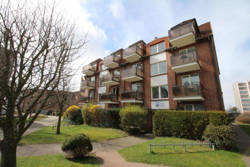 um edifício de apartamentos com arbustos à frente em Residenz Passat Cuxhaven 4 em Cuxhaven