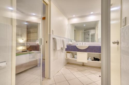 y baño con lavabo y espejo. en Freestyle Resort Port Douglas en Port Douglas