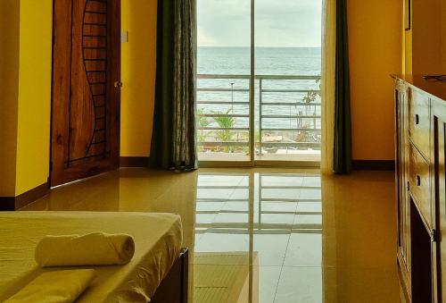 a bedroom with a bed and a view of the ocean at RedDoorz Plus @ Galucksea Beach Resort in Caore