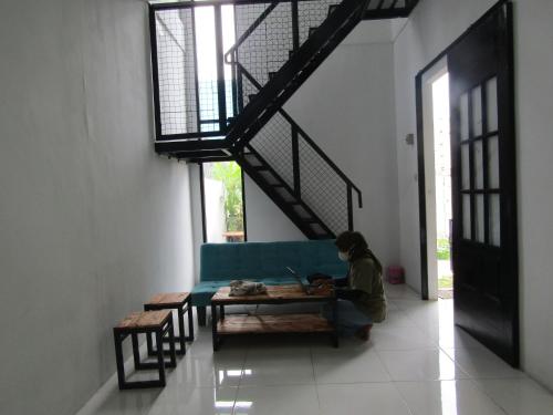a person sitting at a table with a laptop at Rumah Kembar DI kawasan wisata lembang in Citeureup 1
