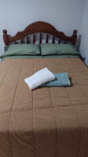 a bed with a white towel on top of it at Tan Ushuaia in Ushuaia