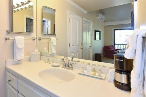 baño con lavabo y espejo grande en 703 Cottages at Silverado residence en Napa