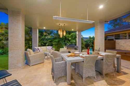 an outdoor dining room with a table and chairs at Riverside Breeze - luxury family retreat with pool in Port Macquarie