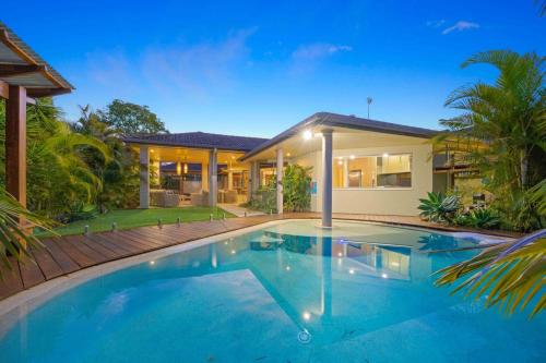 a swimming pool in front of a house at Riverside Breeze - luxury family retreat with pool in Port Macquarie