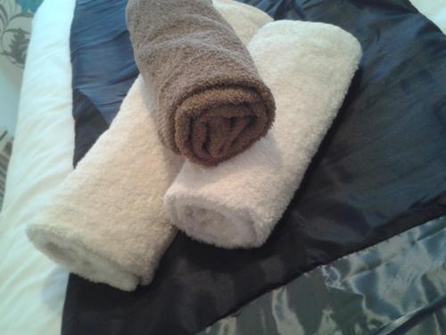 Una toalla encima de la cama con una toalla marrón en St Hilda Guest House, en Bridlington