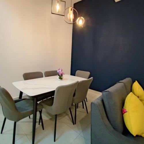uma sala de jantar com uma mesa e cadeiras e um sofá em W39WarmStay@GoldenHills/NightMarket/4R/BBQ em Brinchang