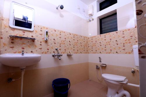 a bathroom with a sink and a toilet and a window at Railview inn Bhubaneswar in Bhubaneshwar
