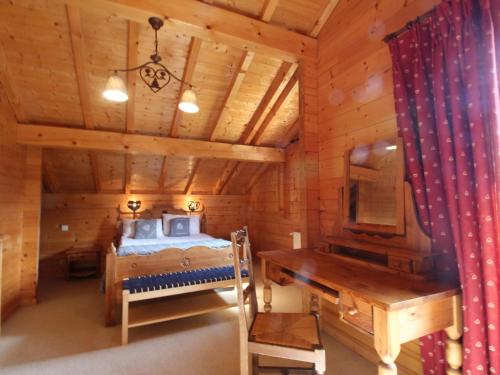 a bedroom in a log cabin with a bed and a desk at Chalet 5 chambres pour 10 pers, proche ski bus, terrasse, buanderie, tout confort - FR-1-572-27 in Arâches-la-Frasse