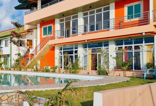 ein Apartmenthaus mit einem Pool davor in der Unterkunft RedDoorz Plus @ Galucksea Beach Resort in Caore