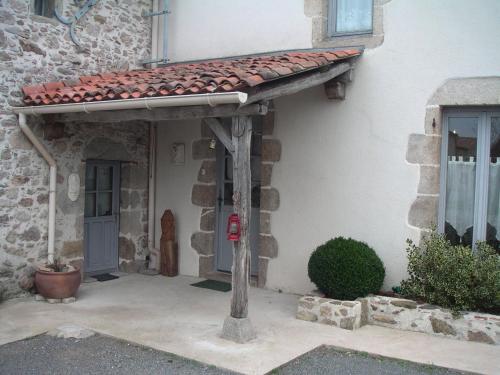 awning on the side of a building with a door at Chambre d'hôte du Plessis in Beaurepaire