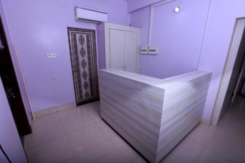 a white bathroom with a wooden counter in a room at Railview inn Bhubaneswar in Bhubaneshwar