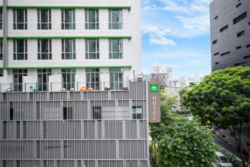 a white building with a sign in front of it at ibis Styles Singapore Albert in Singapore