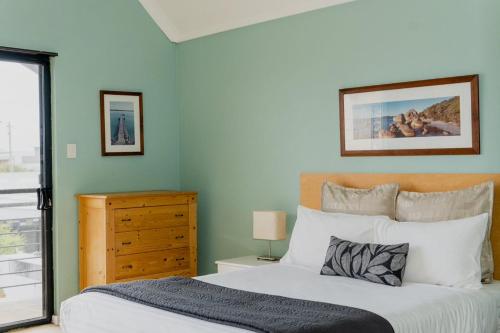 a bedroom with a bed and a dresser at Albany Harbourside Apartments And Houses in Albany