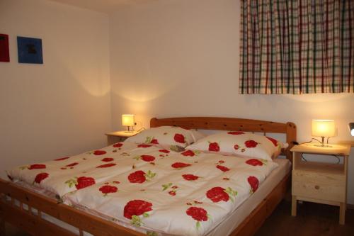 ツェル・アム・ゼーにあるFerienwohnung Mitterleithengutのベッドルーム1室(赤いバラのベッド1台付)