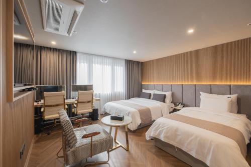 釜山にある동래 덴바스타 호텔のベッド2台とデスクが備わるホテルルームです。