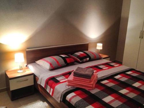 a bedroom with a bed with red and black pillows at Guesthouse Mala Luce Stobreč in Split