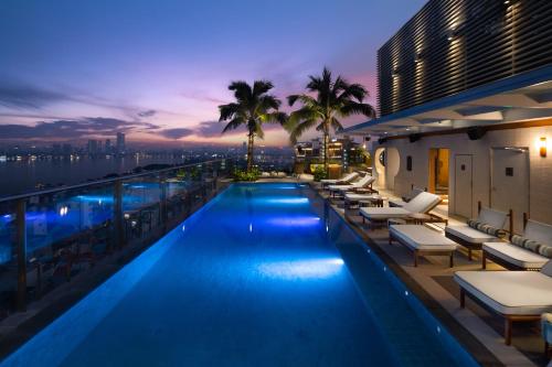 a pool on the roof of a building at night at Fraser Suites Hanoi in Hanoi