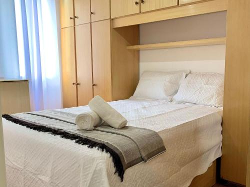um quarto com uma cama branca e toalhas em Apartamento próximo do Tiete Plaza Shopping, com vaga e portaria 24h em Osasco