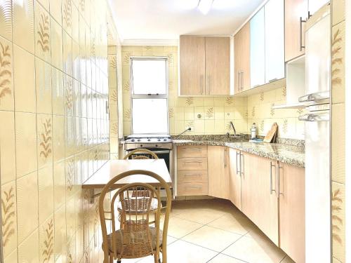 a kitchen with wooden cabinets and a table and chairs at Apartamento próximo do Tiete Plaza Shopping, com vaga e portaria 24h in Osasco