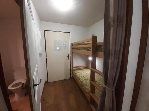 Cette petite chambre comprend des lits superposés et une porte. dans l'établissement Brides-les-Bains - Studio coin montagne 4 pers avec balcon, parking, WiFi - Résidence Cybèle - FR-1-512-257, à Brides-les-Bains