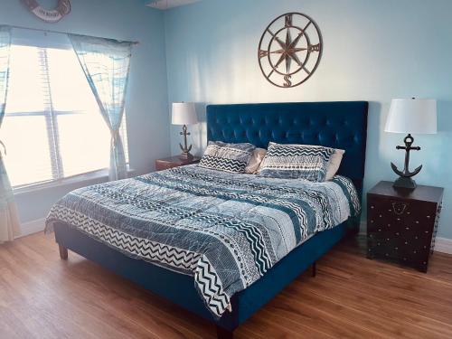 a bedroom with a blue bed and a window at Two Bedroom Condo With Views Of The Beach & Gulf in St. Pete Beach