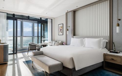 um quarto com uma grande cama branca e uma secretária em The Langham, Gold Coast and Jewel Residences em Gold Coast